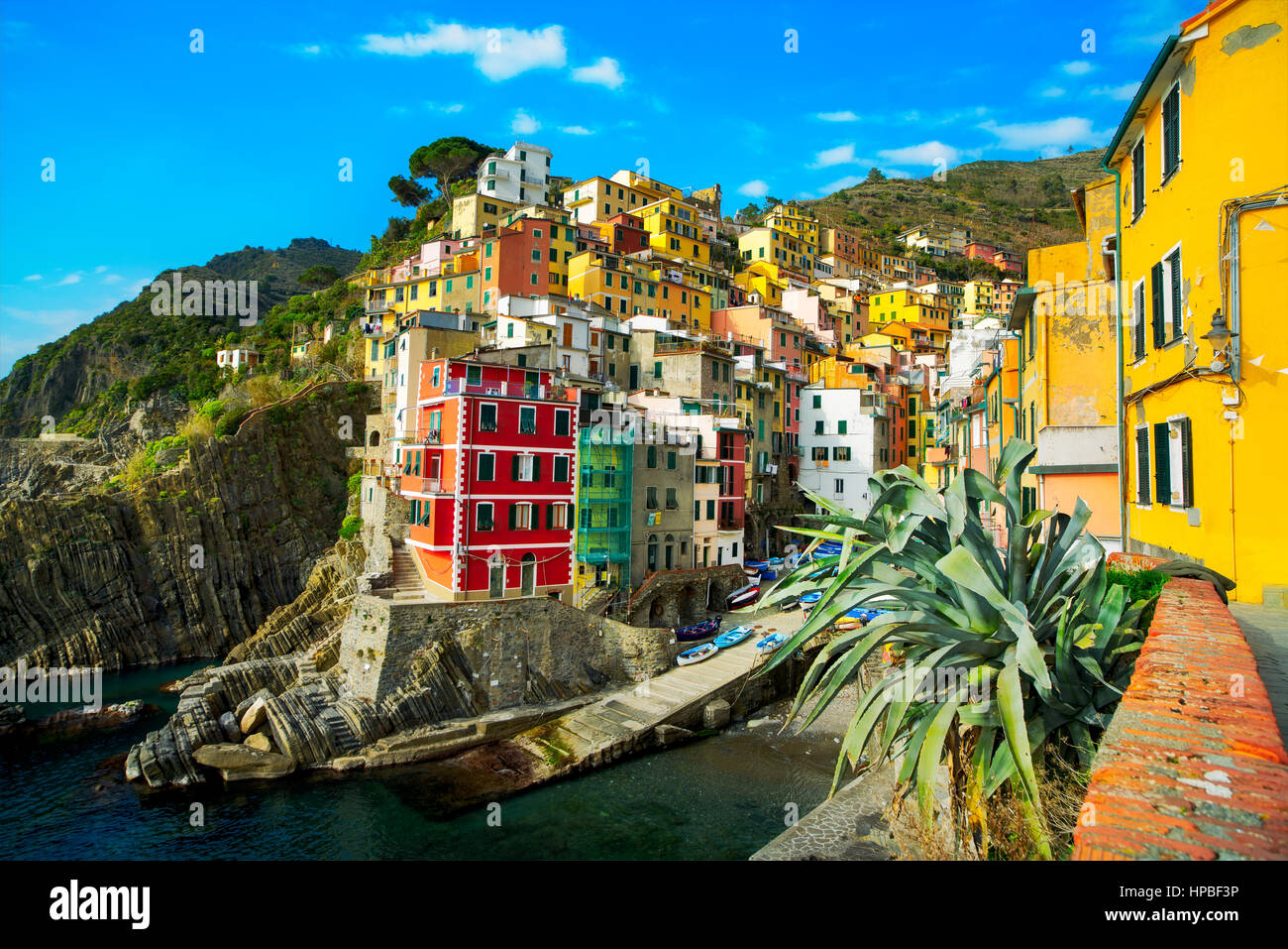Riomaggiore village on cliff rocks and sea at sunset., Seascape in Five lands, Cinque Terre National Park, Liguria Italy Europe. Long Exposure Stock Photo