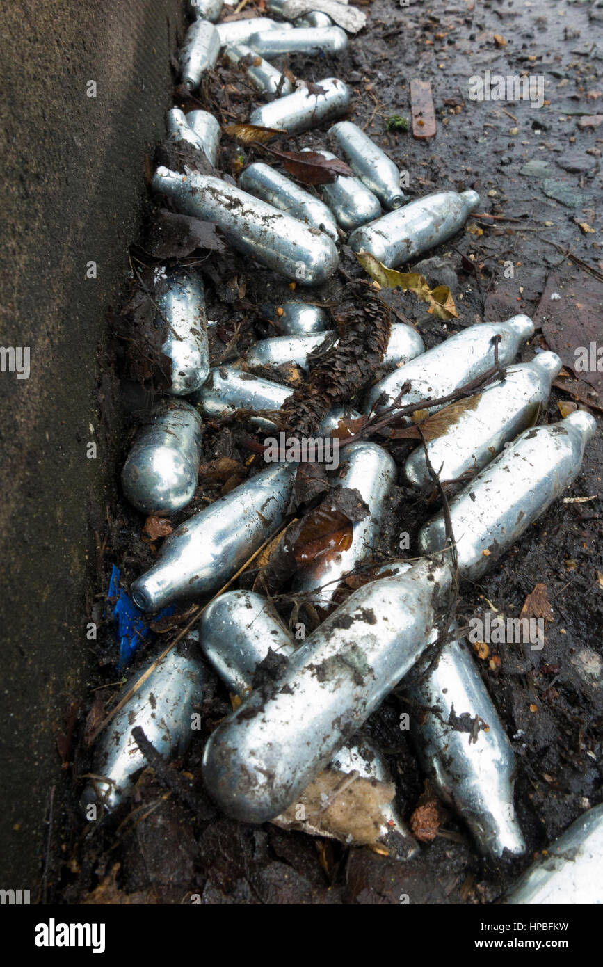 Nitrous Oxide gas / laughing gas ampule / ampules / canister / canisters left litter / rubbish in a gutter after inhaling gasses for creational use UK Stock Photo