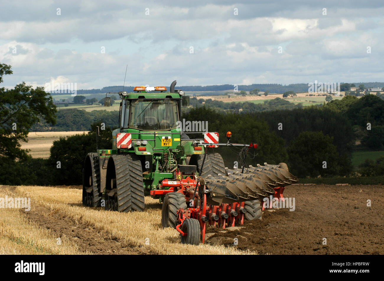 John Deere 9520 high horse powered tractor ploughing stubble in with a 10 furrow reversible plough. Yorkshire, UK. Stock Photo