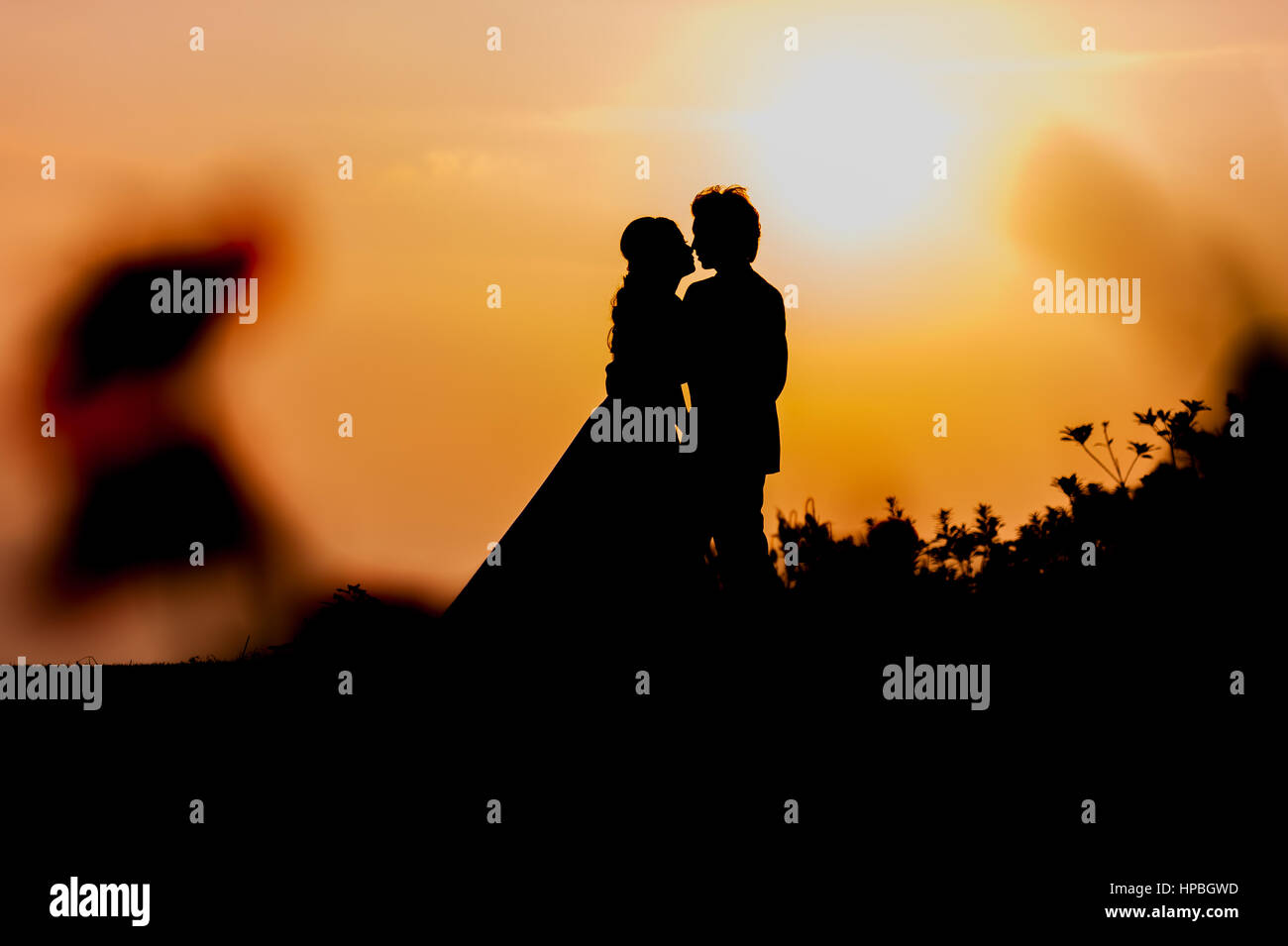 Silhouette of Asian Bride and Groom Standing on Mountain at Sunset ...