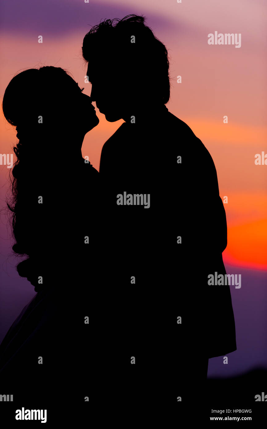 Silhouette of Embracing Asian Bride and Groom at Sunset Stock Photo - Alamy
