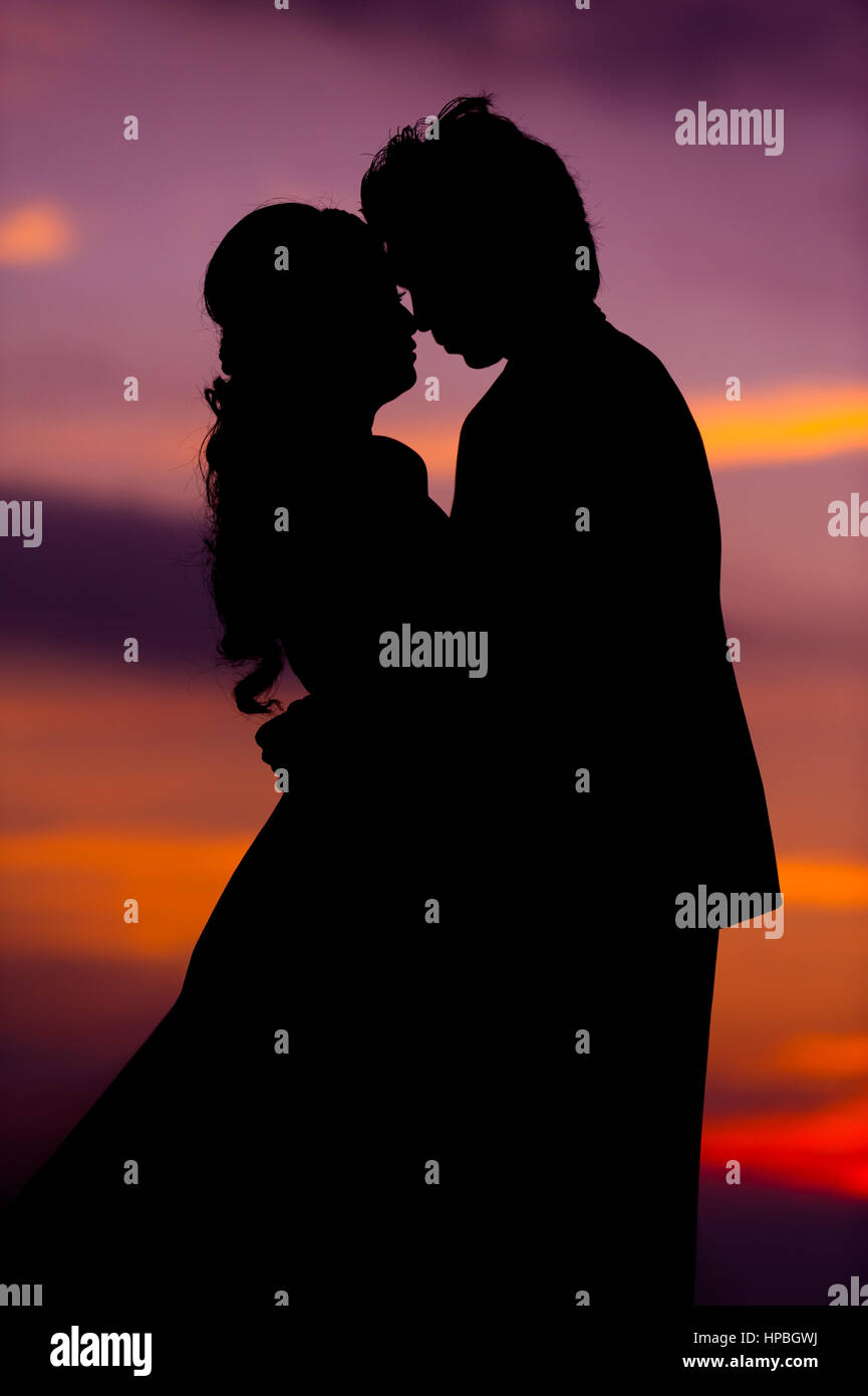 Silhouette of Embracing Asian Bride and Groom at Sunset Stock Photo - Alamy