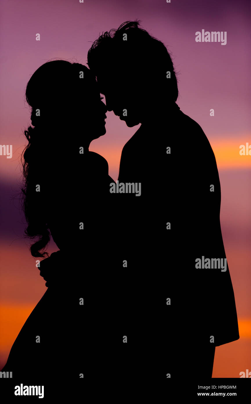 Silhouette of Embracing Asian Bride and Groom at Sunset Stock Photo - Alamy