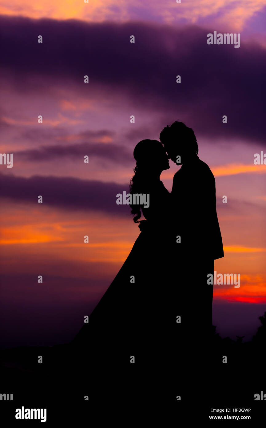 Silhouette of Embracing Asian Bride and Groom at Sunset Stock Photo - Alamy