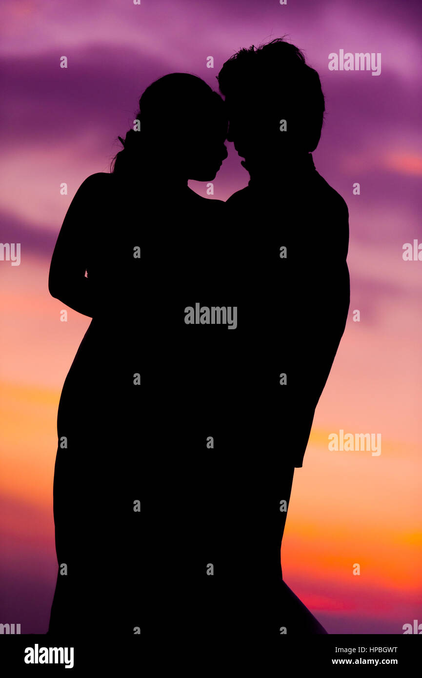 Silhouette of Embracing Asian Bride and Groom at Sunset Stock Photo - Alamy