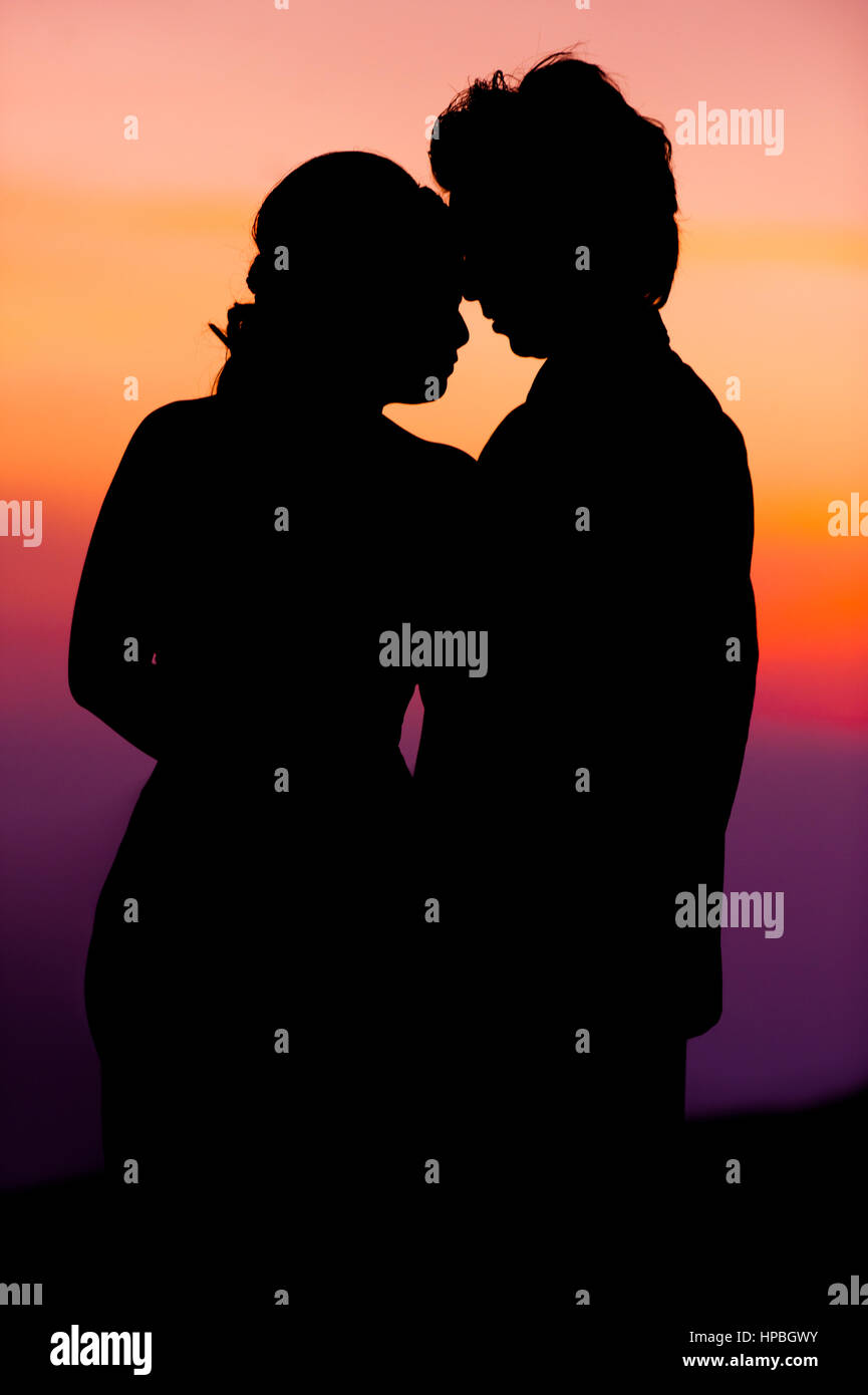 Silhouette of Embracing Asian Bride and Groom at Sunset Stock Photo - Alamy