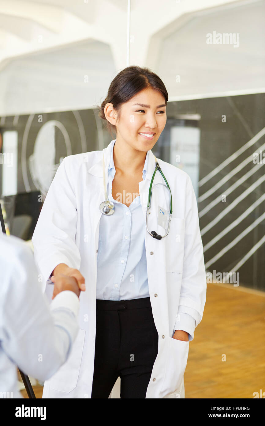 Woman as doctor shaking hands with medical seminar instructor Stock