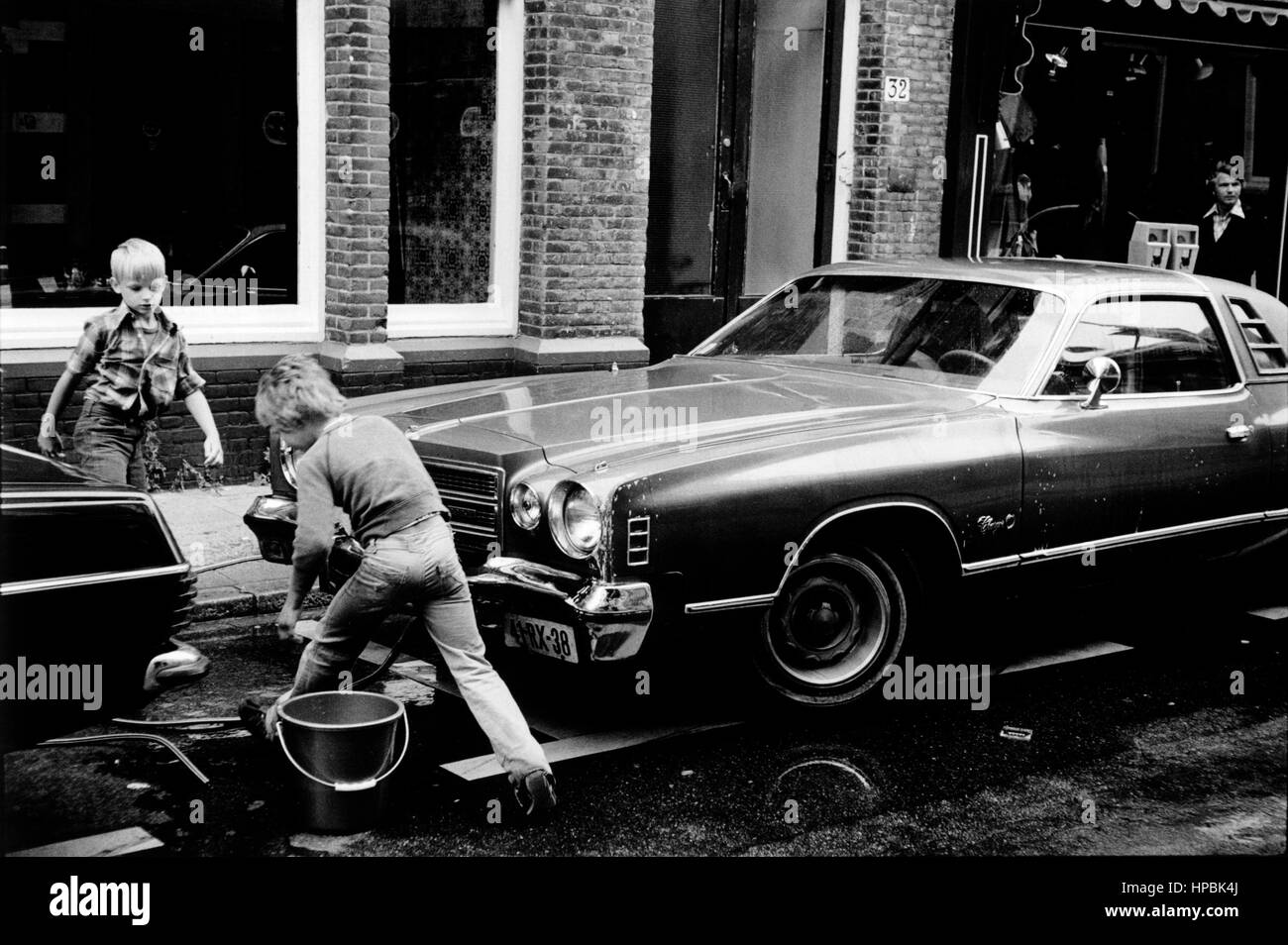 AJAXNETPHOTO. 1979. SCHEVENINGEN, HOLLAND. - CAR WASH - YOUNGSTERS CLEANING CARS IN THE STREET.  PHOTO:JONATHAN EASTLAND/AJAX  REF:CAR 79 Stock Photo