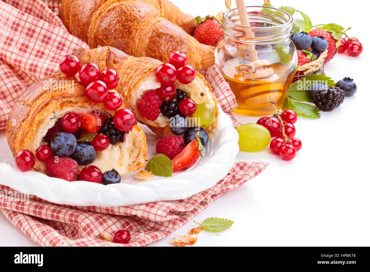 Croissants Et Fruits Rouges Fresh croissants with fruits. Isolated on white background Stock Photo ...