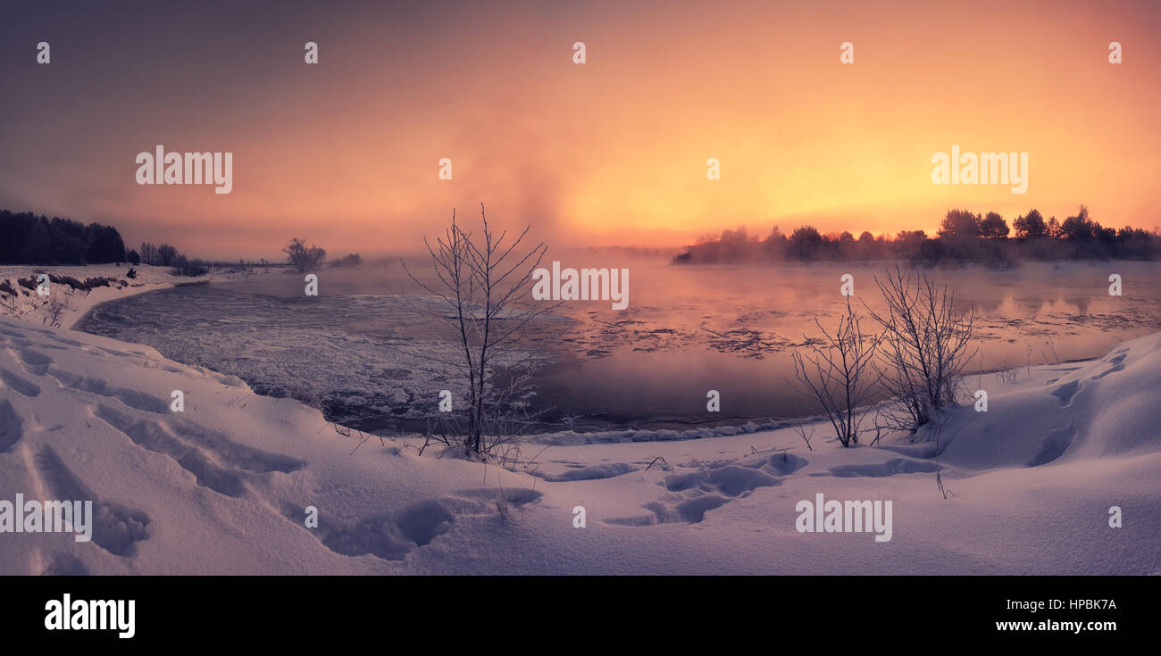 Colorful orange winter dawn on the lake with trace on snow Stock Photo