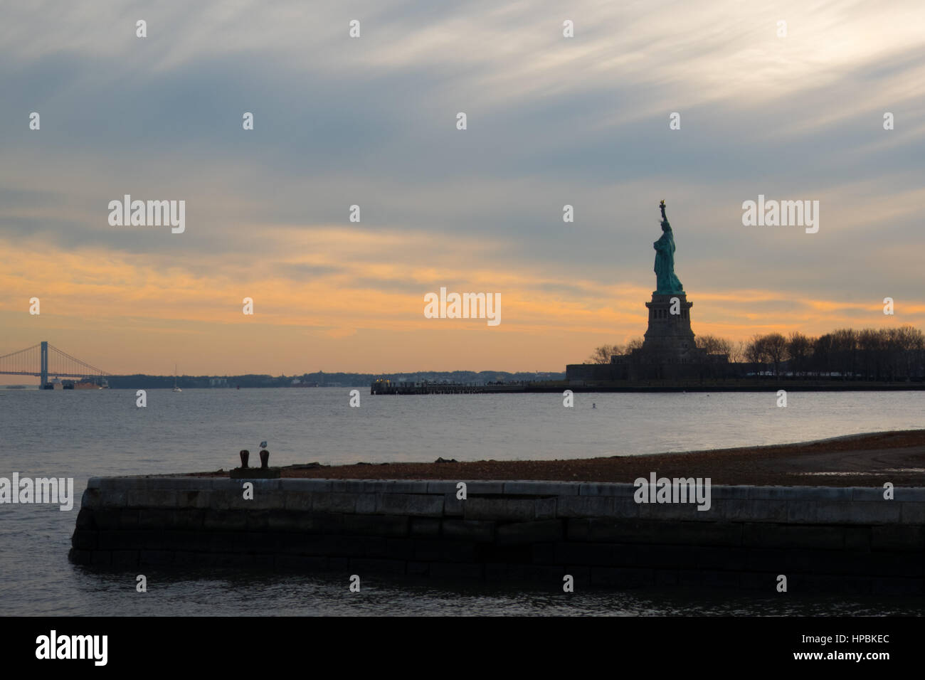 Silhouette of the Statue of Liberty at sunset in New York Harbor ...