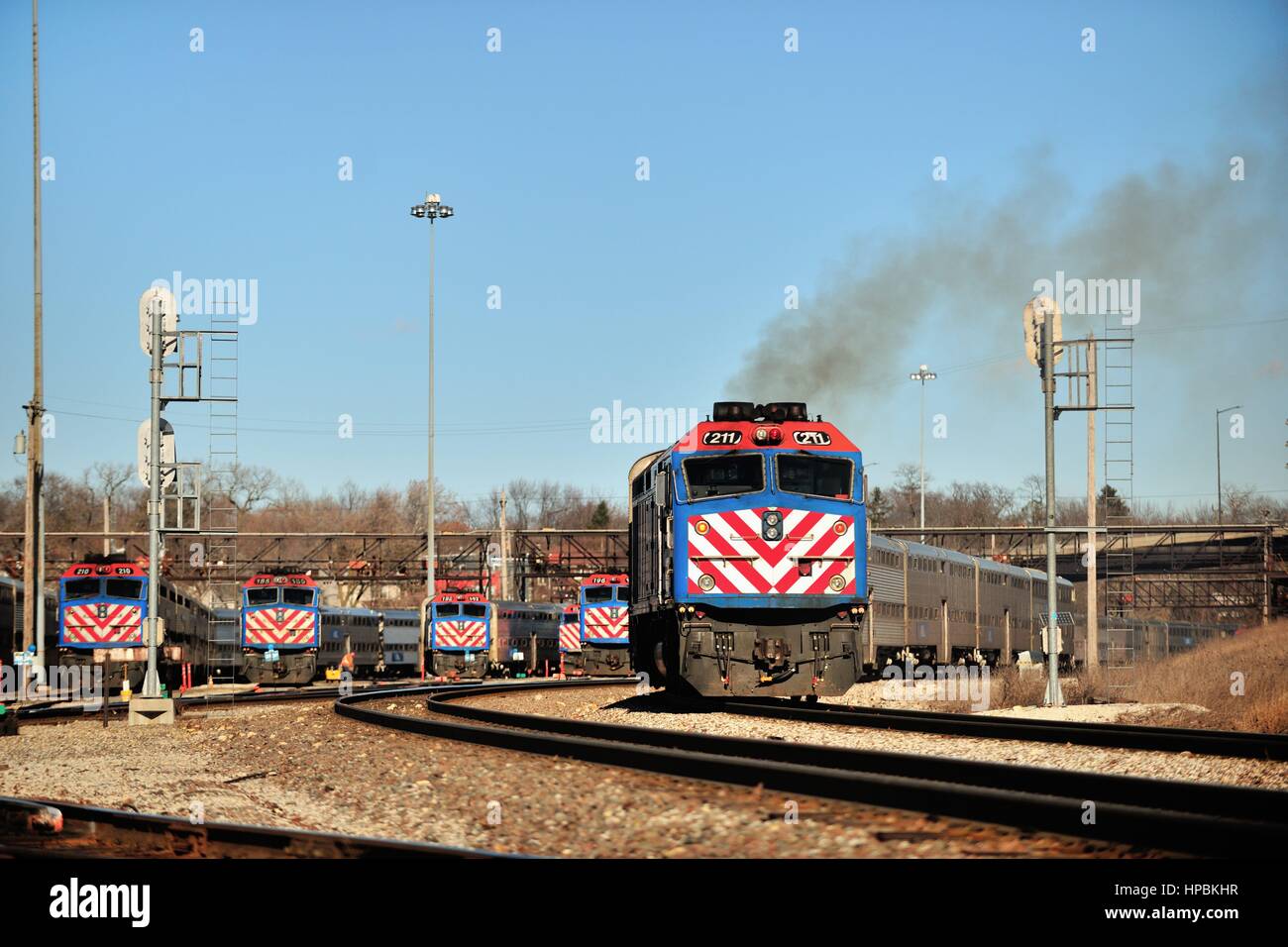 A Metra commuter train passing through a locomotive and equipment storage facility in Aurora, Illinois on its journey to Chicago from Aurora. USA. Stock Photo