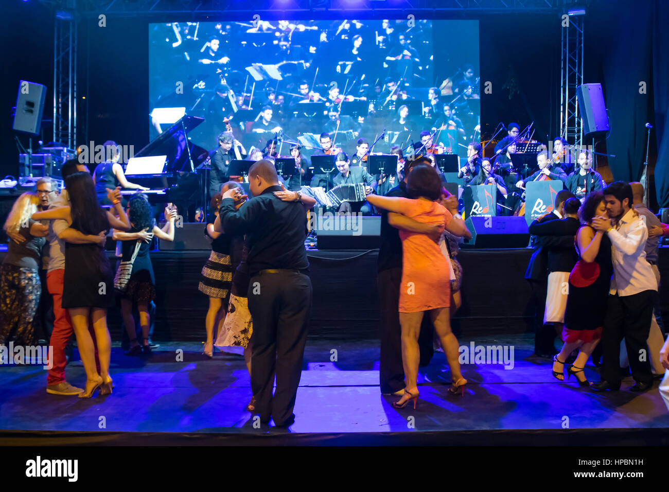 Couples dancing Tango in milonga, party where you only dance tango, milonga and vals criollo with the Tango Orchestra of the Music School Network. Tan Stock Photo