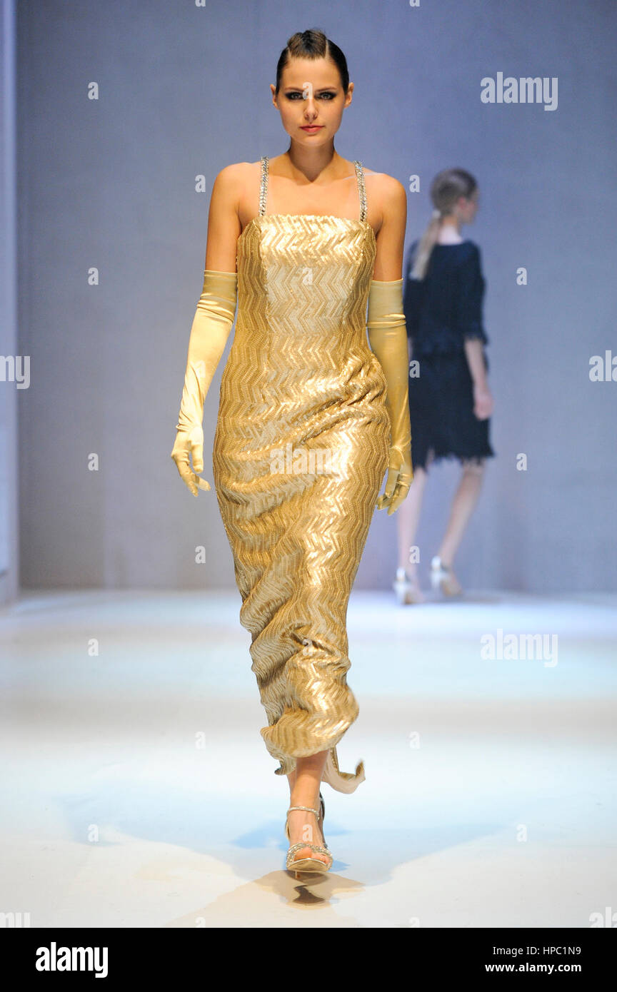 Fashion model wearing a gold maxi dress and opera gloves on the catwalk at Moda. Moda, the UK's biggest trade fashion show for independent fashion buyers, takes place between 19th-21st February 2017 at the NEC, Birmingham, UK. 20th February 2017. Showcasing the Autumn/Winter 2017/2018 collections, Moda features womenswear, lingerie, swimwear, menswear, shoes, and accessories. Aside from the exhibition hall trade stands, two catwalks feature regular fashion shows across the three days. Credit: Antony Nettle/Alamy Live News Stock Photo