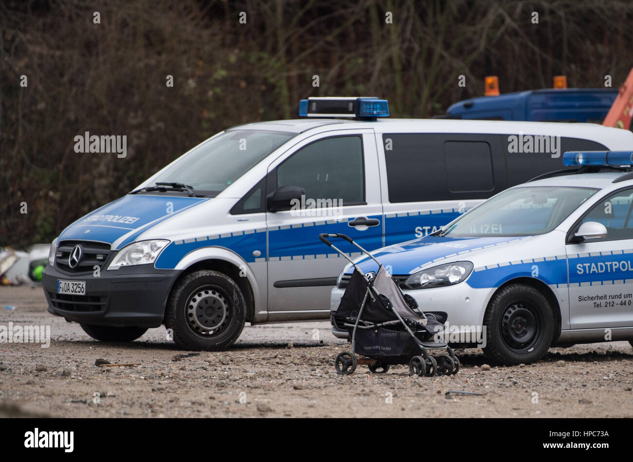 An empty stroller can be seen before two police vehicles on a commercial property in the Gutleutviertel district on the outskirts of Frankfurt am Main, Germany, 21 February 2017. The handbuilt huts of the property's residents have been torn down. Several dozen Romanians were living in the wooden sheds. Photo: Susann Prautsch/dpa Stock Photo