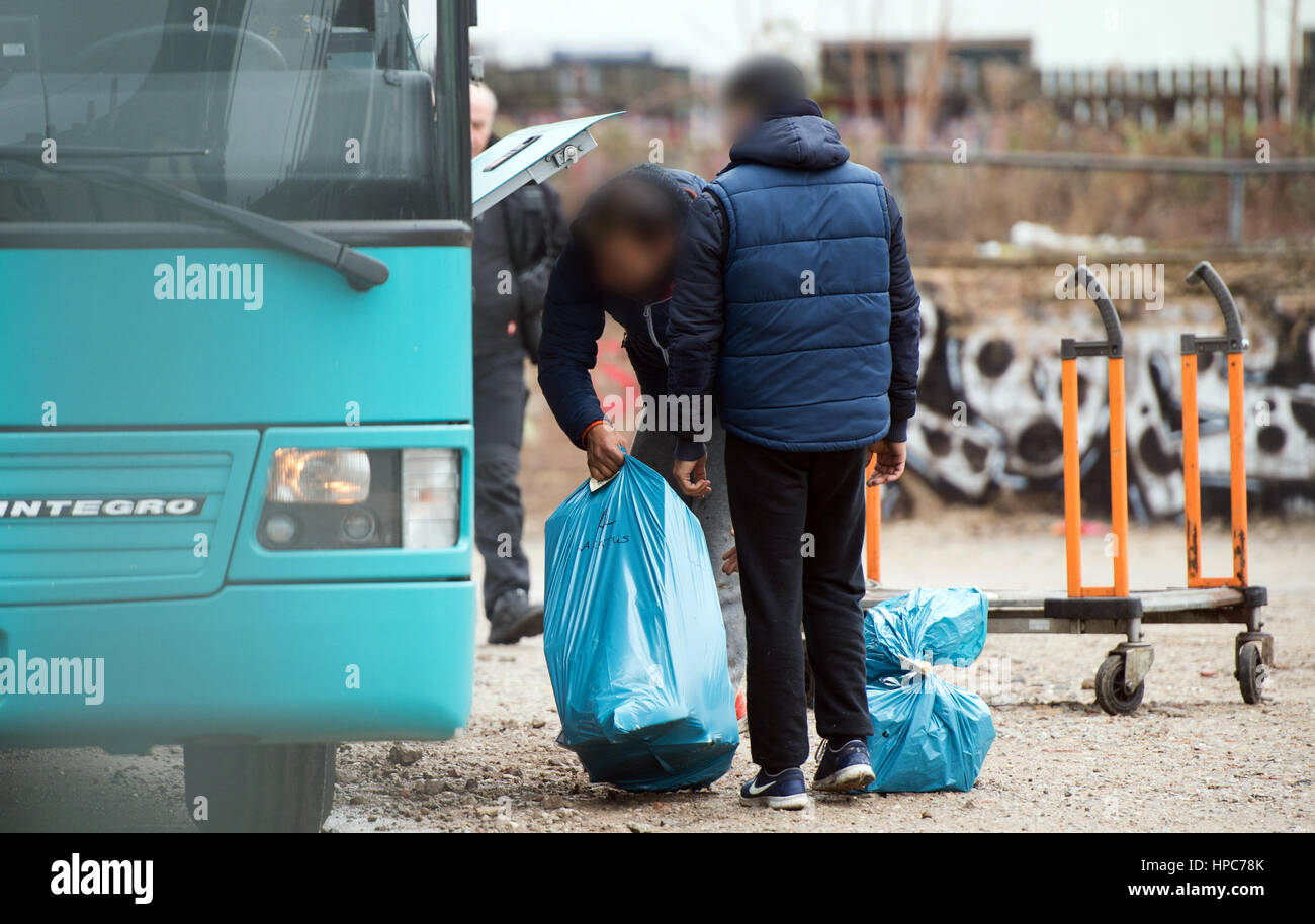 Two men pack garbage bags with their belongings onto a special bus that will bring them to an accommodation at a commercial property in the Gutleutviertel district on the outskirts of Frankfurt am Main, Germany, 21 February 2017. They were residents of dwellings that were demolished on the property. Several dozen Romanians were living in the wooden sheds. Photo: Susann Prautsch/dpa Stock Photo