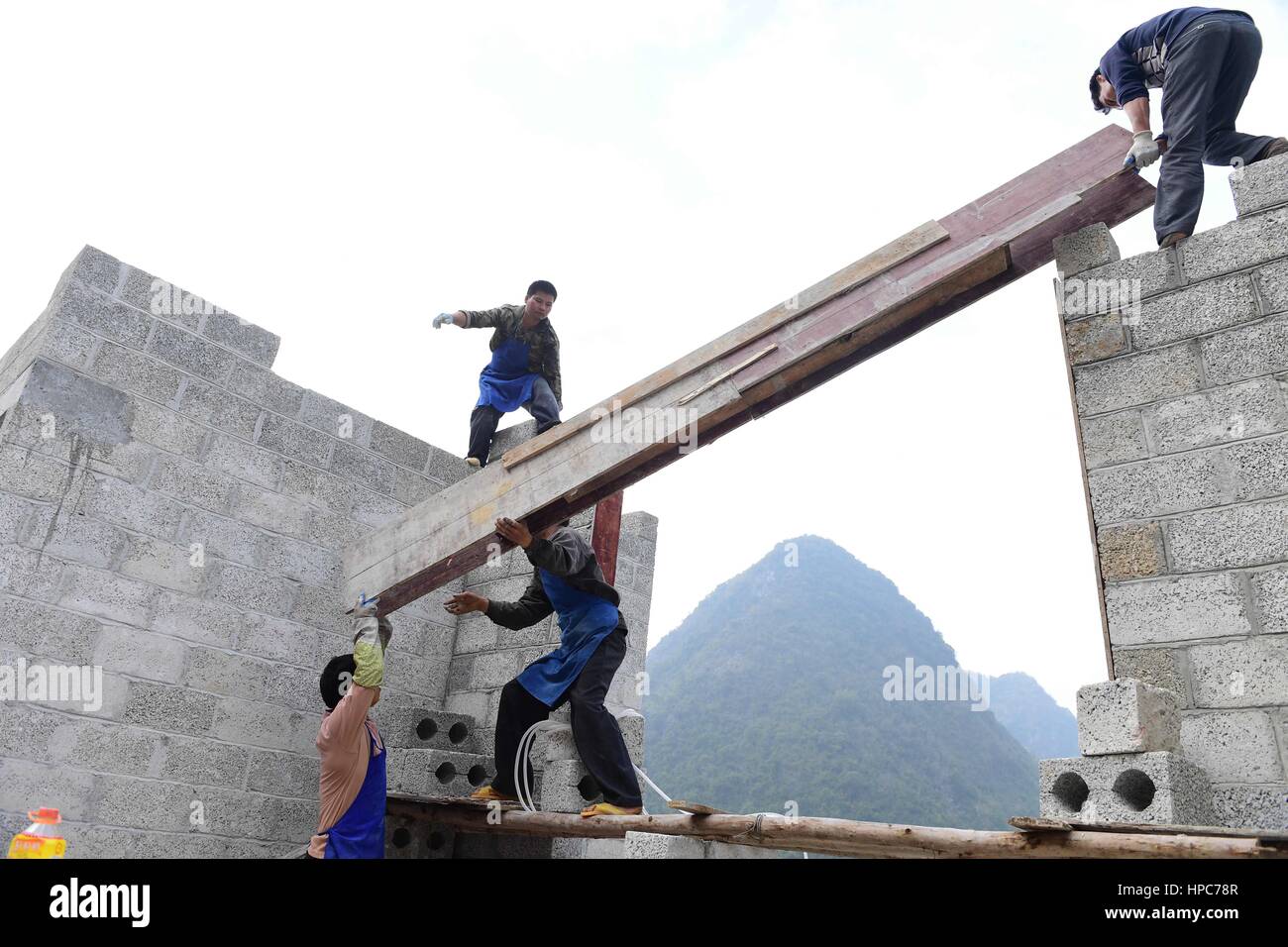 (170221) -- DAHUA, Feb. 21, 2017 (Xinhua) -- Villagers build a house in Nongteng Village of Qibainong Township in Dahua Yao Autonomous County, south China's Guangxi Zhuang Autonomous Region, Jan. 7, 2017. "Cursed by devils" -- that is what the locals say about Qibainong. Named after the rugged karst landforms that surround it, the township has been identified as one of the most inhospitable places on earth by UN officials. However, change is expected soon. Local governments are building roads for every village with more than 20 households. Relocation has been proposed for those who live in ext Stock Photo