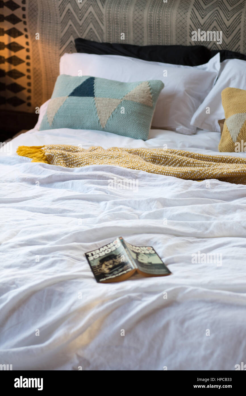 A contemporary white bed with warm lighting Stock Photo