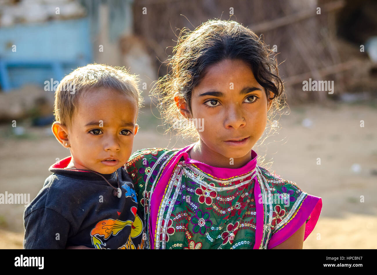 RAJASTHAN, INDIA - NOVEMBER 20, 2016: Unidentified Rajasthani poor young girl holding her brother. Stock Photo