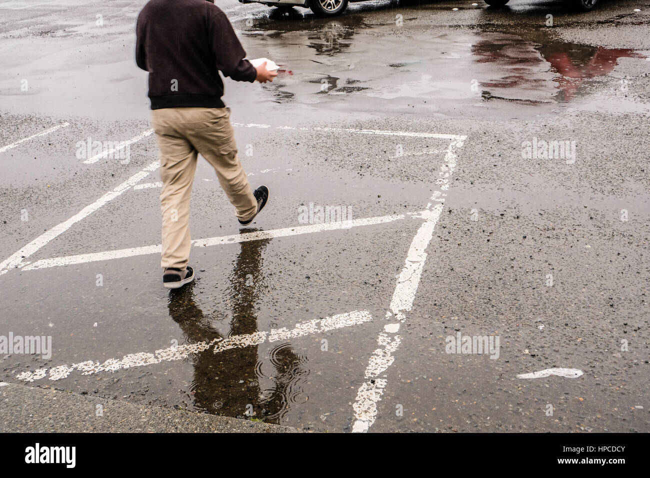 A boy walking in the rain Stock Photo