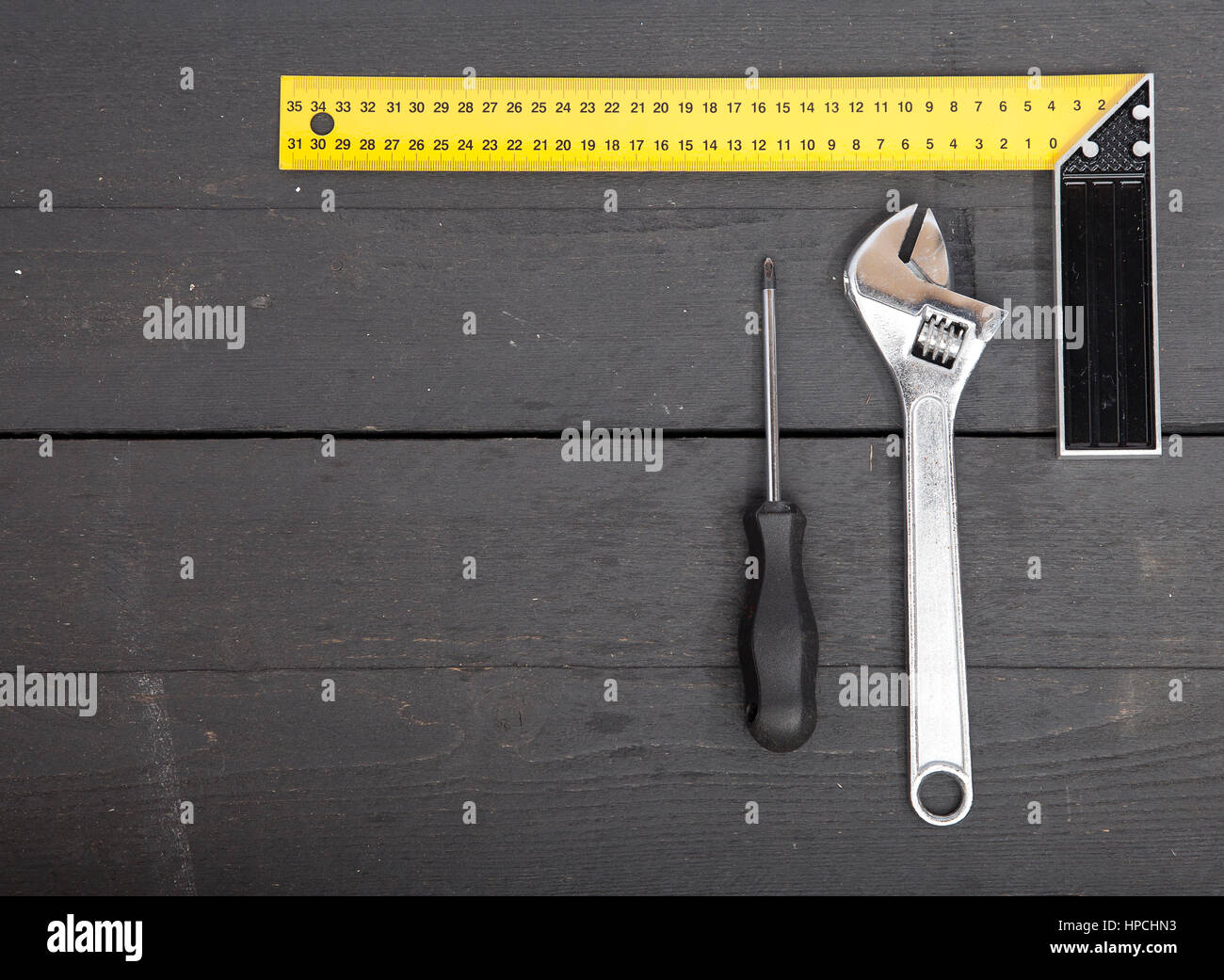 Square, hammer and screwdriver on wooden background Stock Photo