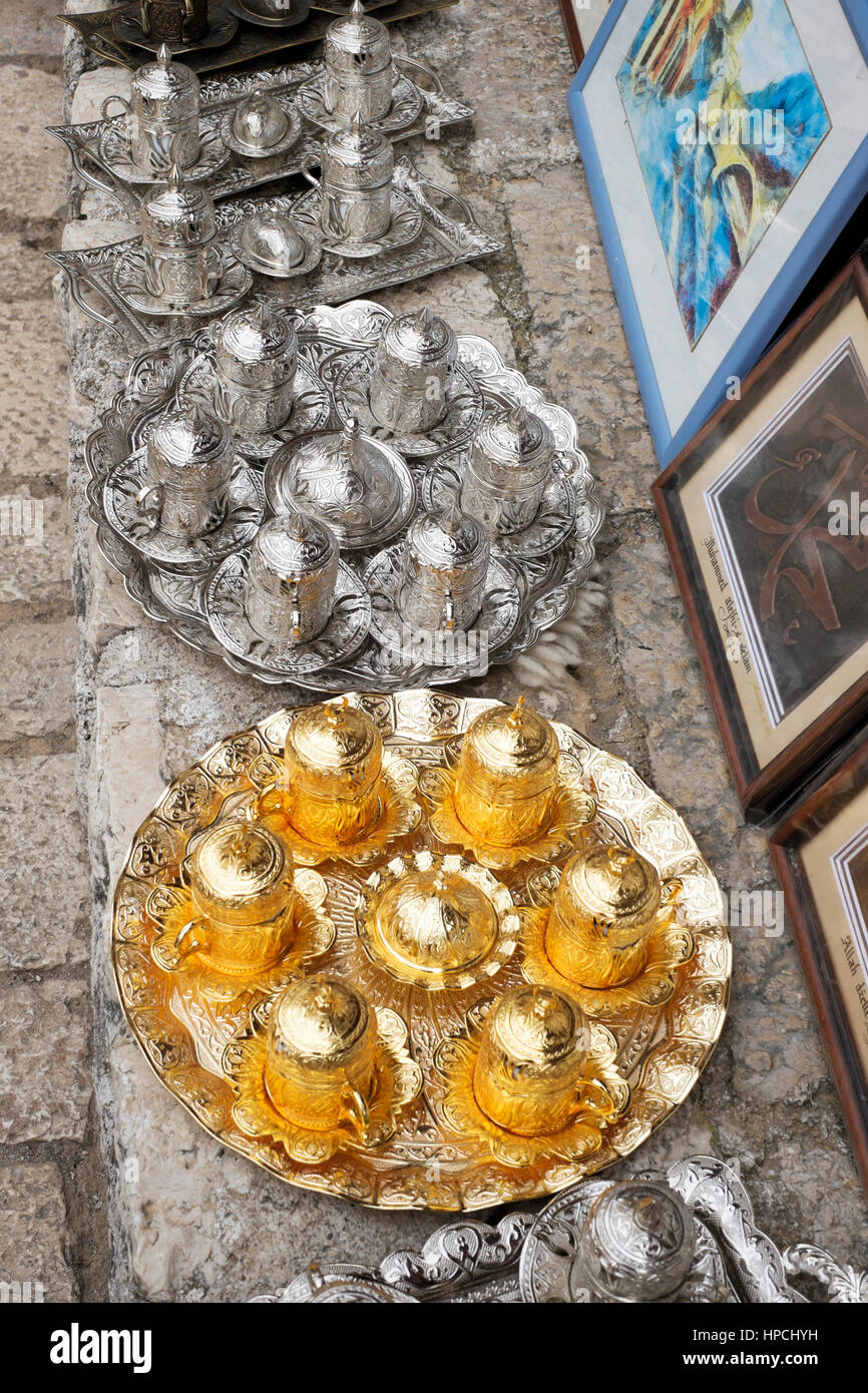 Display of gold and silver Turkish coffee cups with sugar bowls and decorative trays. Stock Photo