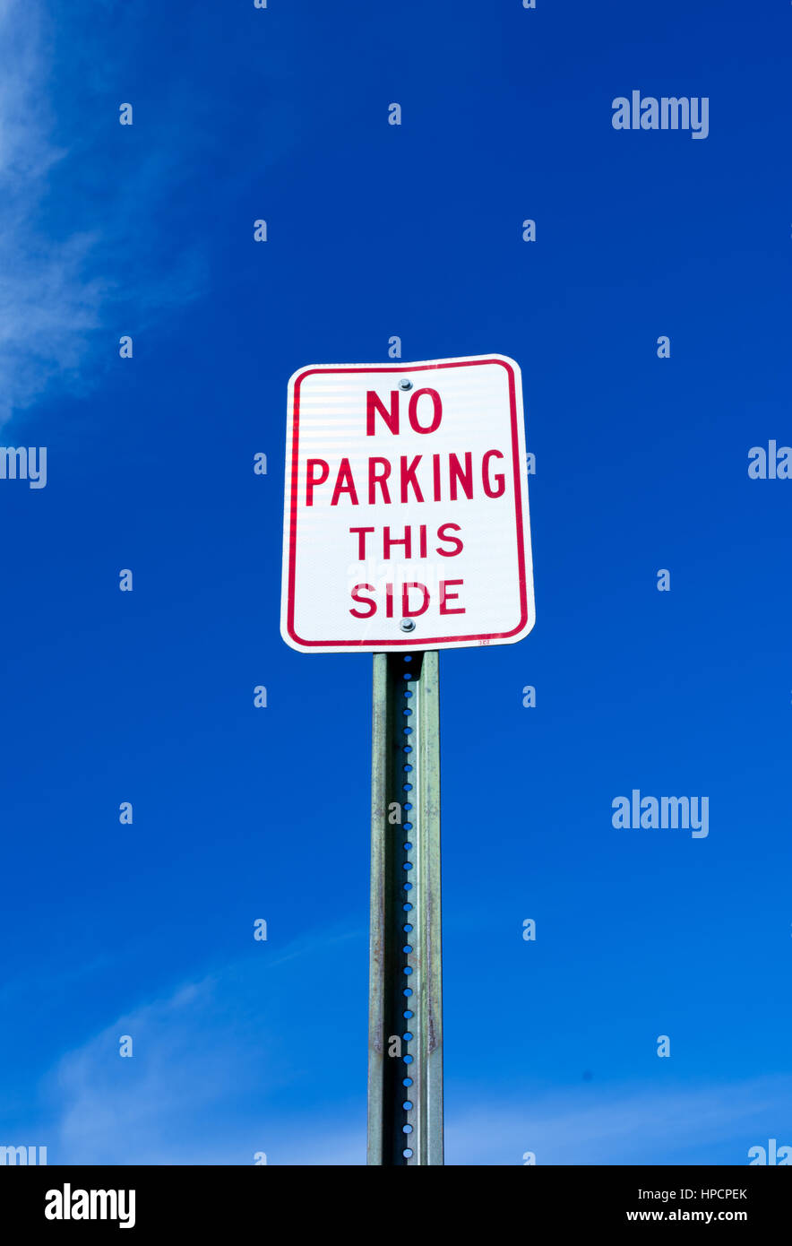 'No parking this side' sign against vibrant blue sky Stock Photo - Alamy