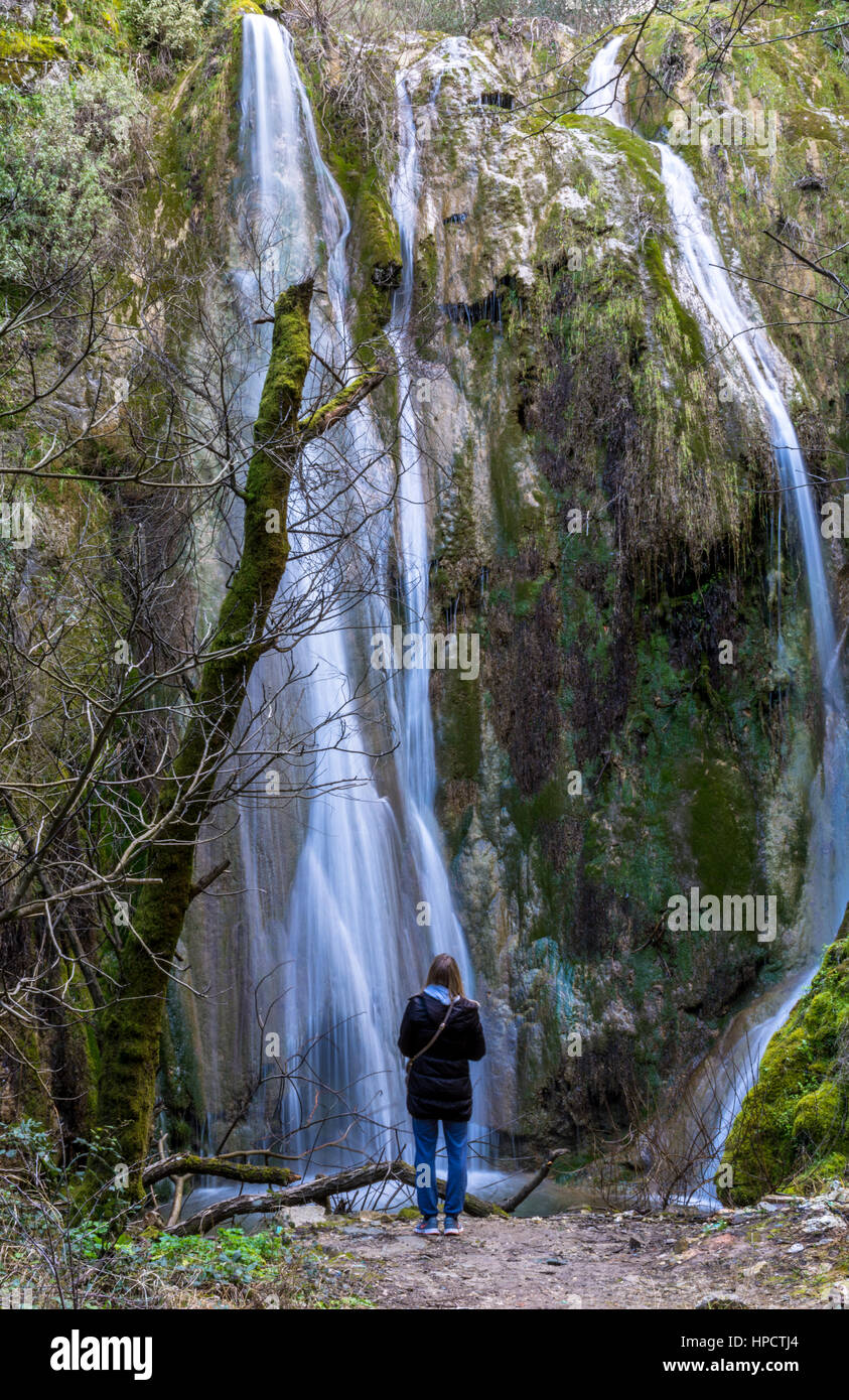 Woman standing alone in front of a waterfall Stock Photo - Alamy