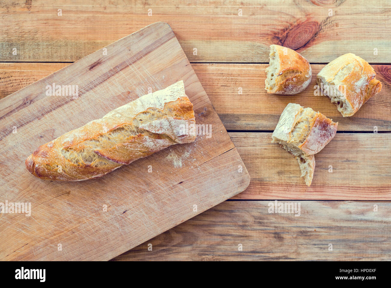 Fresh baguette bread on a wooden table, view from above Stock Photo