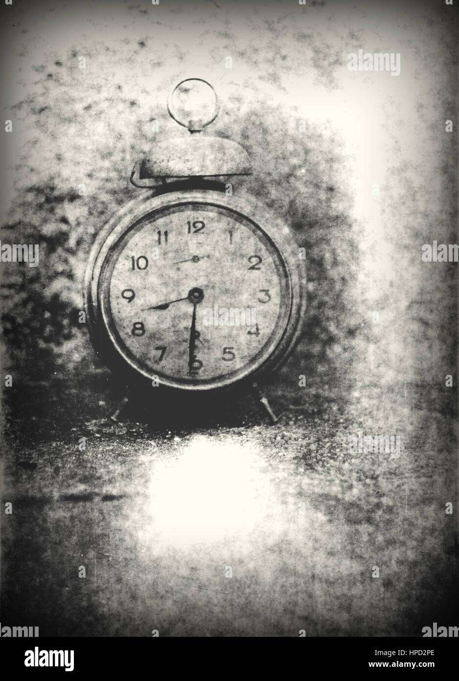 Old photo of the alarm clock - grained, scratched, overexposure and underexposure, unfocused Stock Photo