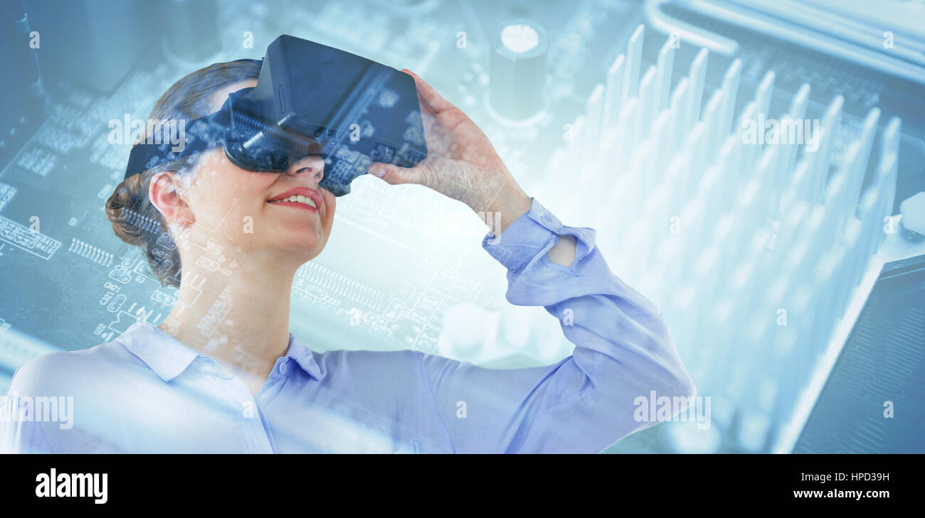 Low angle view of businesswoman using virtual reality headset against micro parts of mother board Stock Photo