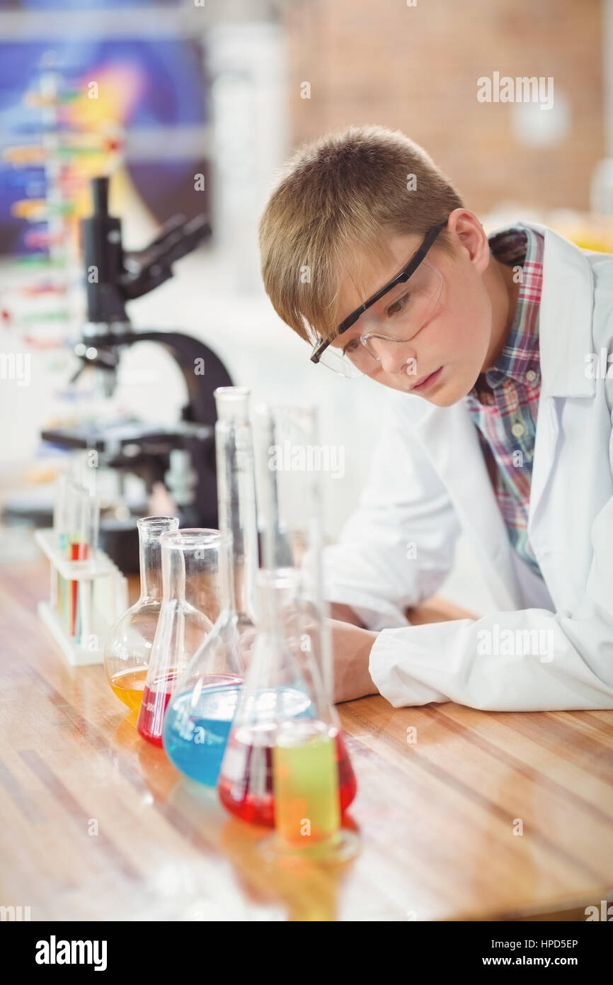 Attentive schoolboy doing a chemical experiment in laboratory at school ...