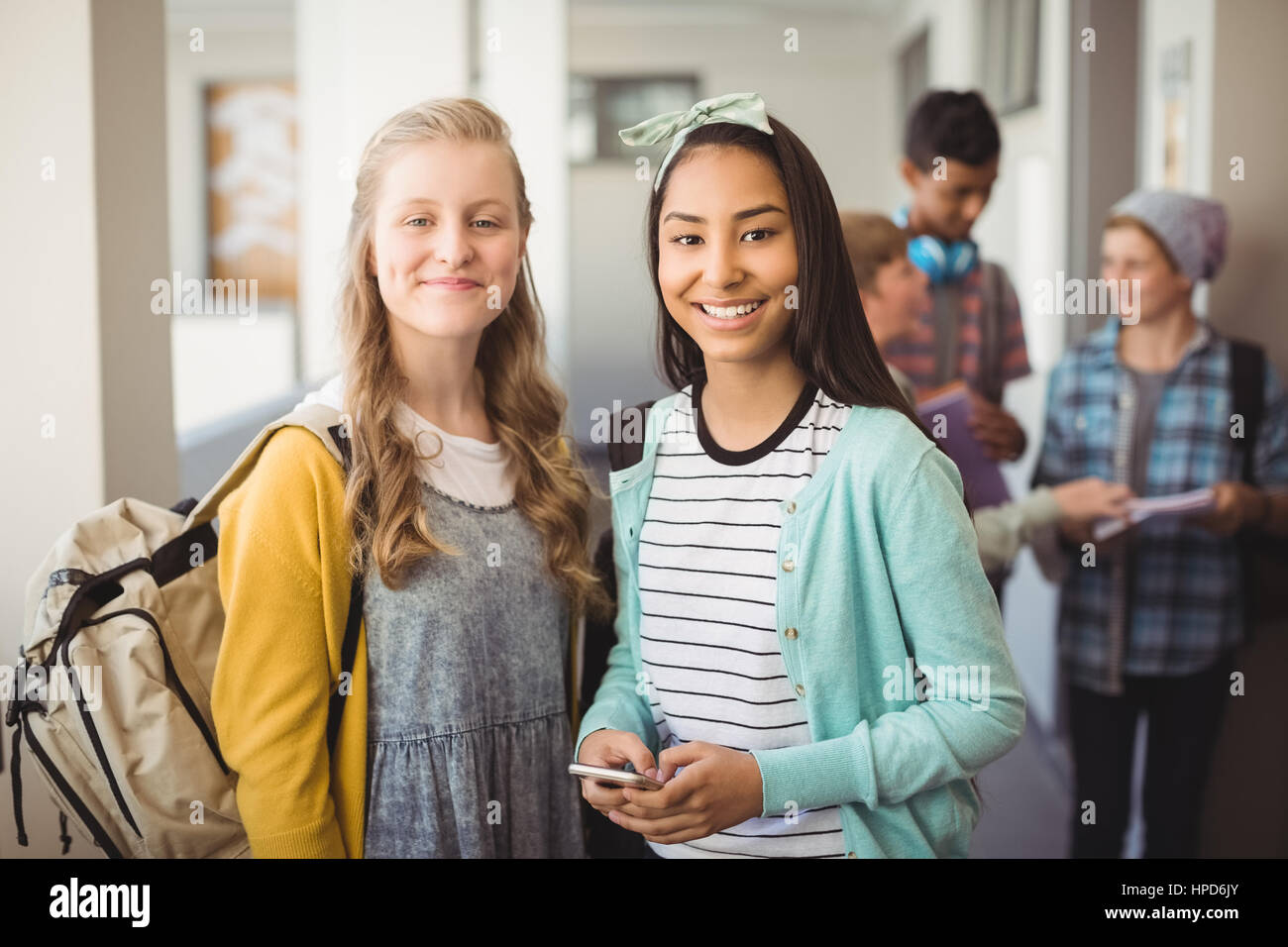 Portrait of smiling schoolgirls standing in corridor at school Stock ...