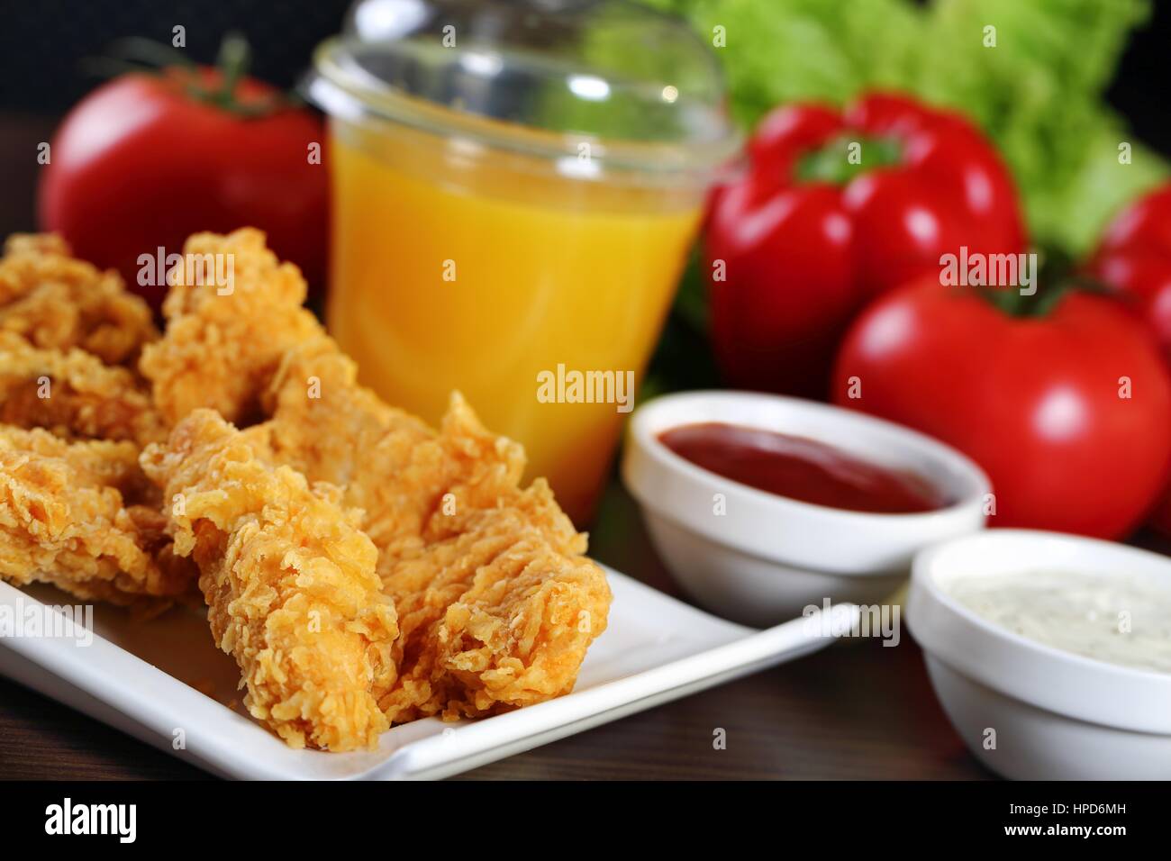 Breaded chicken strips with sauces, tomatoes, peppers Stock Photo Alamy