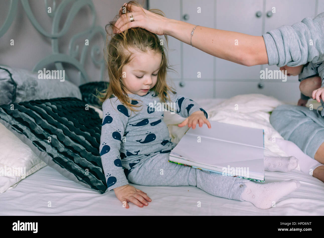 Little girl reading a book sitting in bed Stock Photo Alamy