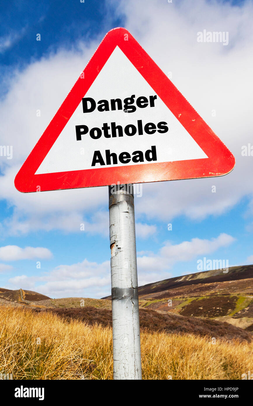 Danger potholes ahead sign UK roads danger dangerous because of potholes everywhere Stock Photo