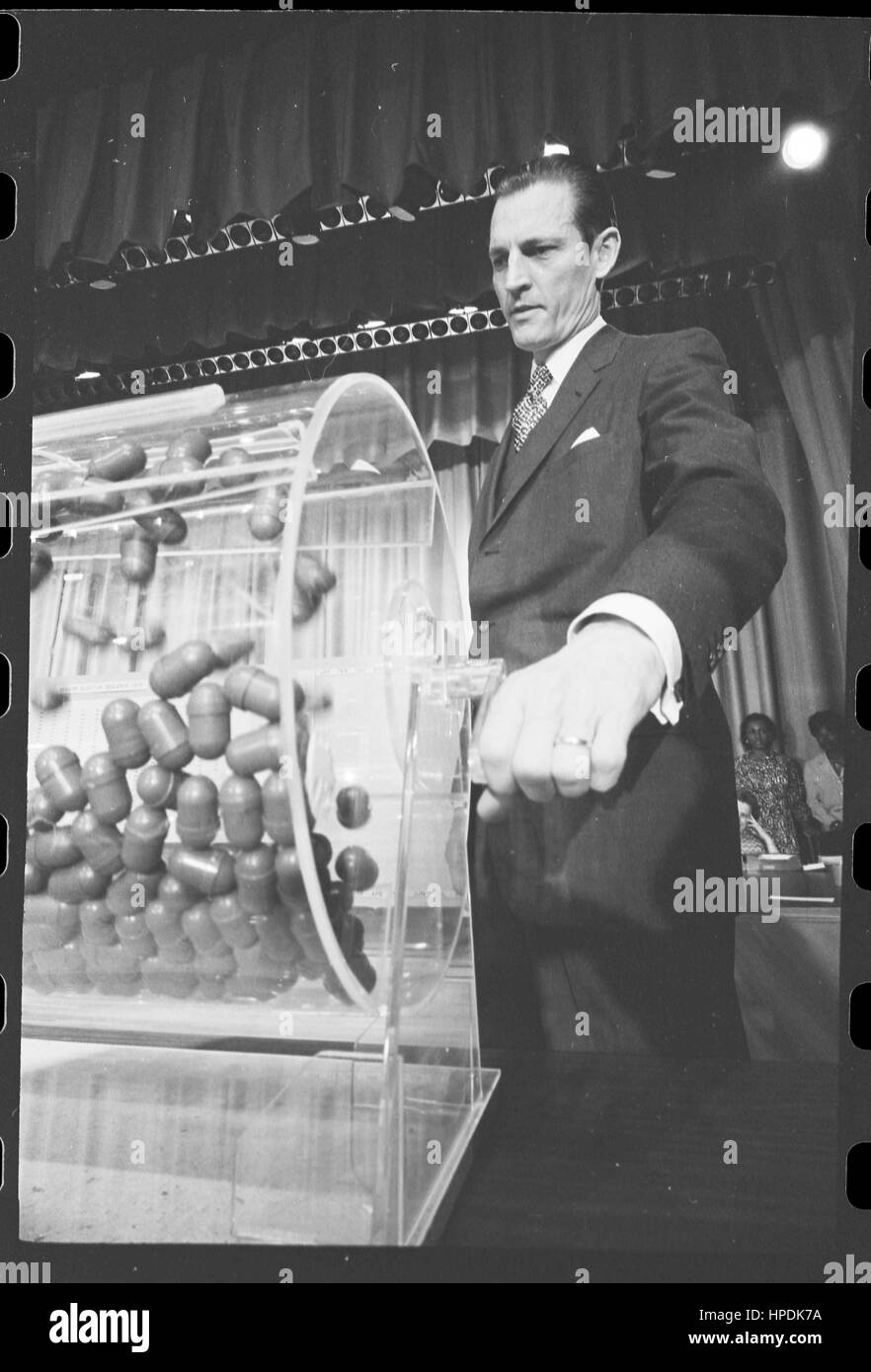 Curtis W Tarr, director of the Selective Service System, turns the drum containing capsules of draft numbers at the annual draft lottery, Washington, DC, 02/02/1972. Stock Photo