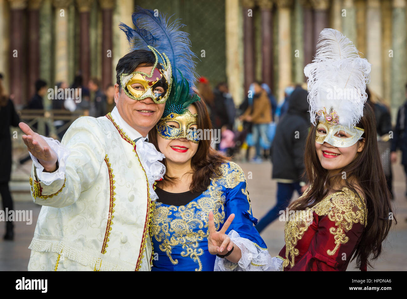 man and woman with young lady wearing colombina masks during Venice Carnival Stock Photo