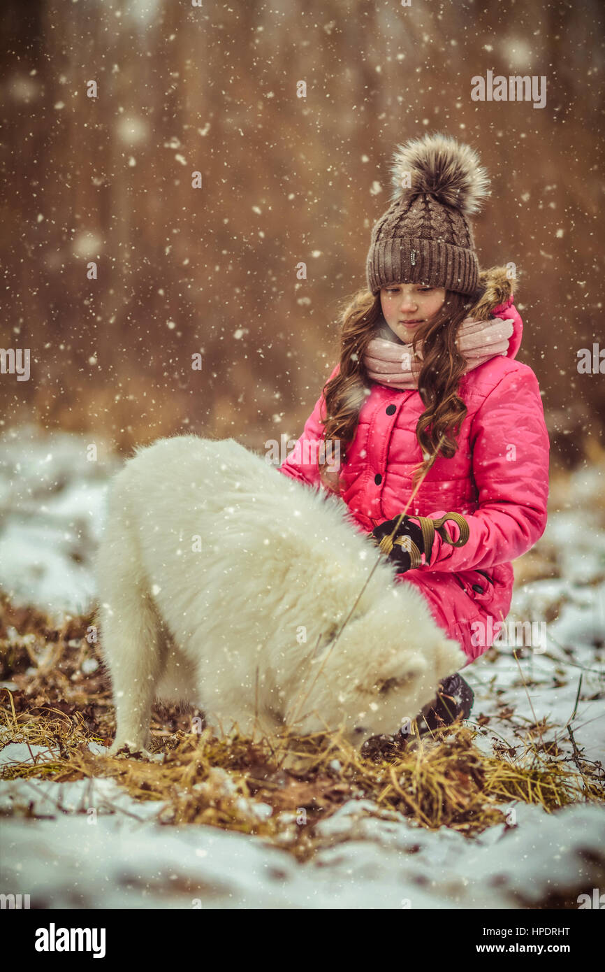 Happy girl with dog in winter forest Stock Photo - Alamy