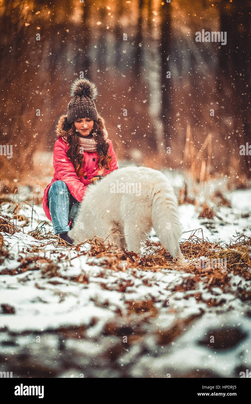 Happy girl with dog in winter forest Stock Photo - Alamy