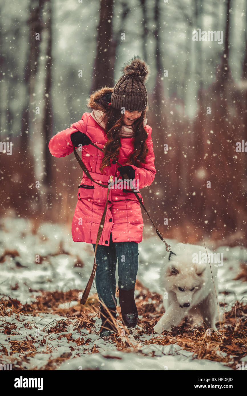Happy girl with dog in winter forest Stock Photo - Alamy