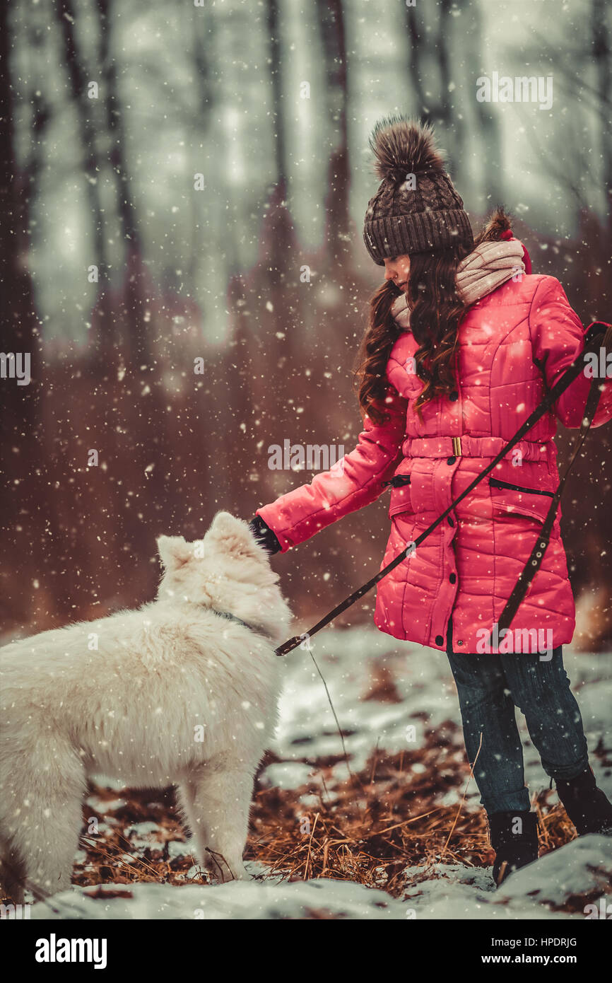 Happy girl with dog in winter forest Stock Photo - Alamy