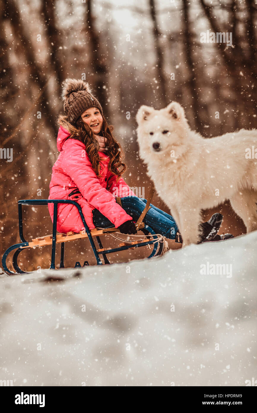 Happy girl with dog in winter forest Stock Photo - Alamy