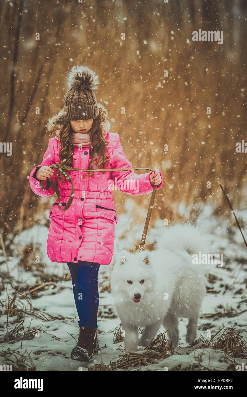 Happy girl with dog in winter forest Stock Photo - Alamy