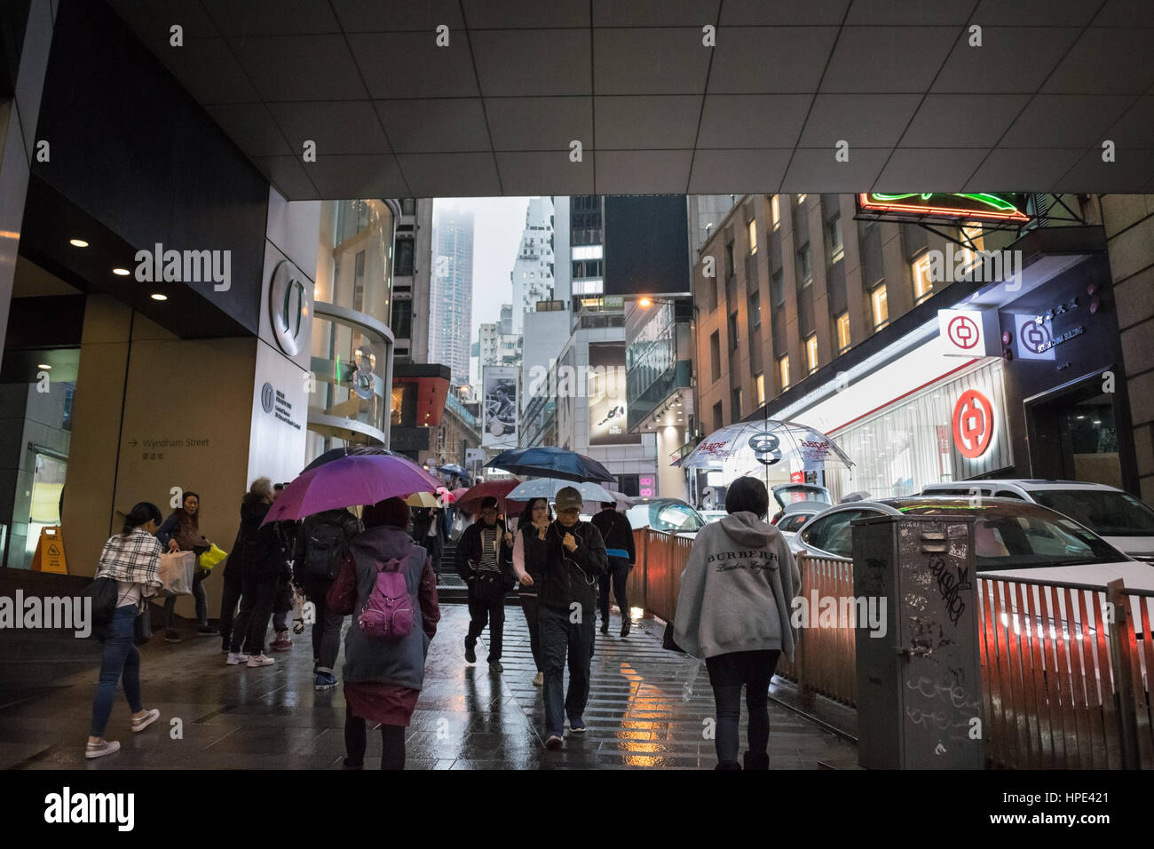 Pedestrians carrying umbrellas on a rainy day in Hong Kong Stock Photo