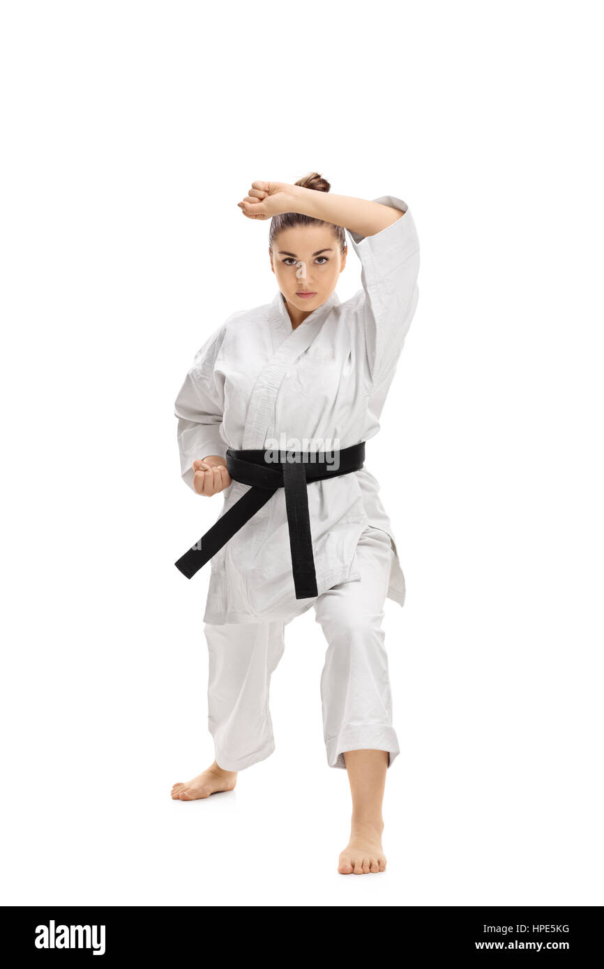 Full length portrait of a girl wearing a kimono doing a karate kata isolated on white background Stock Photo