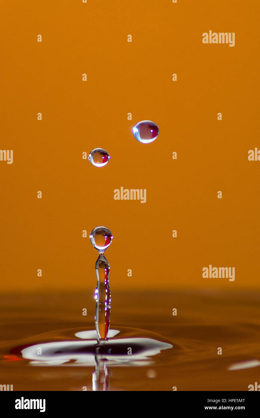 Colourful Droplets against Orange Background Stock Photo