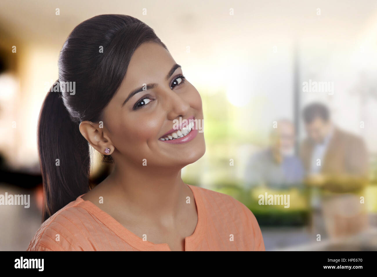 Portrait of a young smiling woman in office Stock Photo - Alamy
