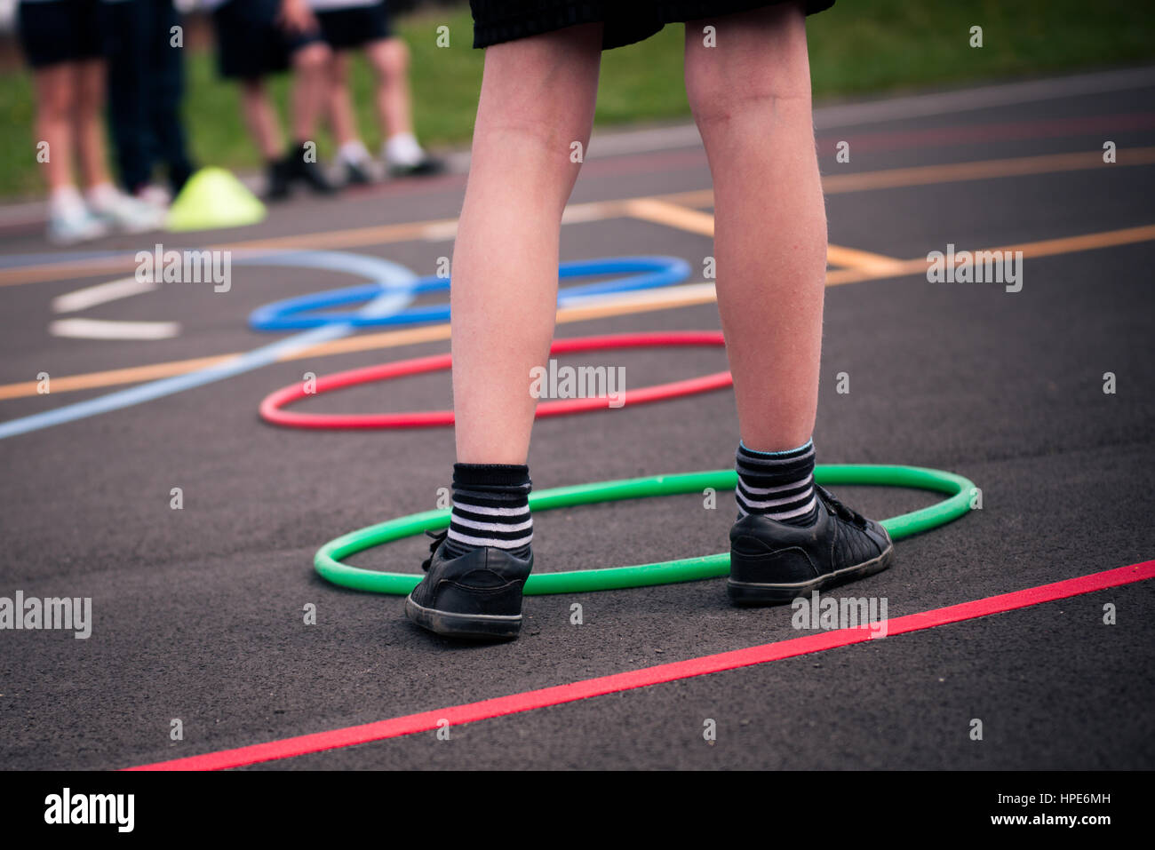 One Leg Student legs of lone student playing sports in school yard with group or team ...