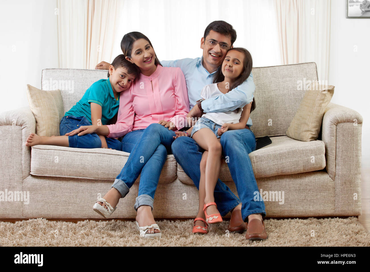 Portrait of family with two children on sofa Stock Photo